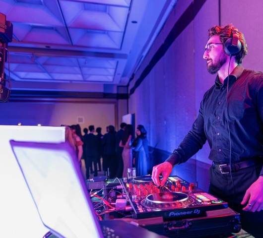 DJ Pizzo mixing behind Pioneer decks at an event